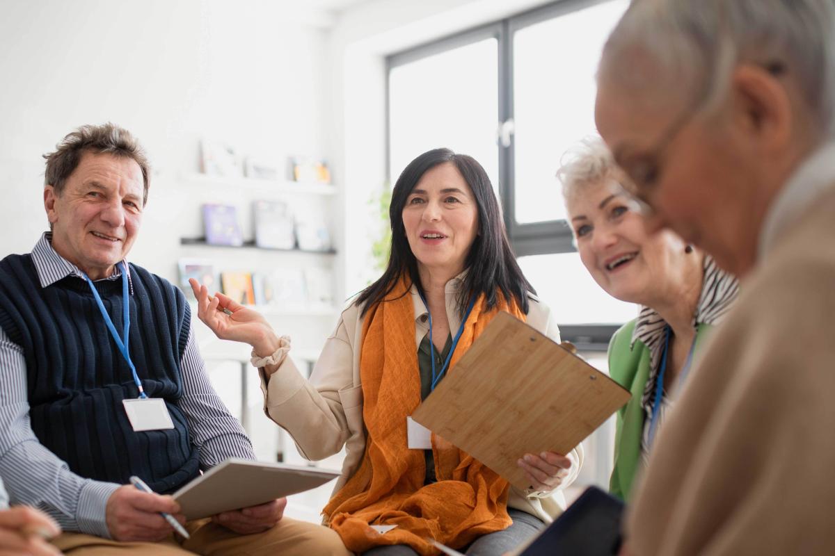 woman with clipboard facilitating a group discussion