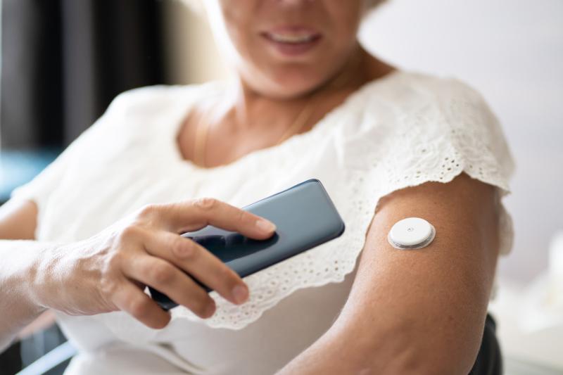 An old lady using a smart device detecting the sensor on her arm
