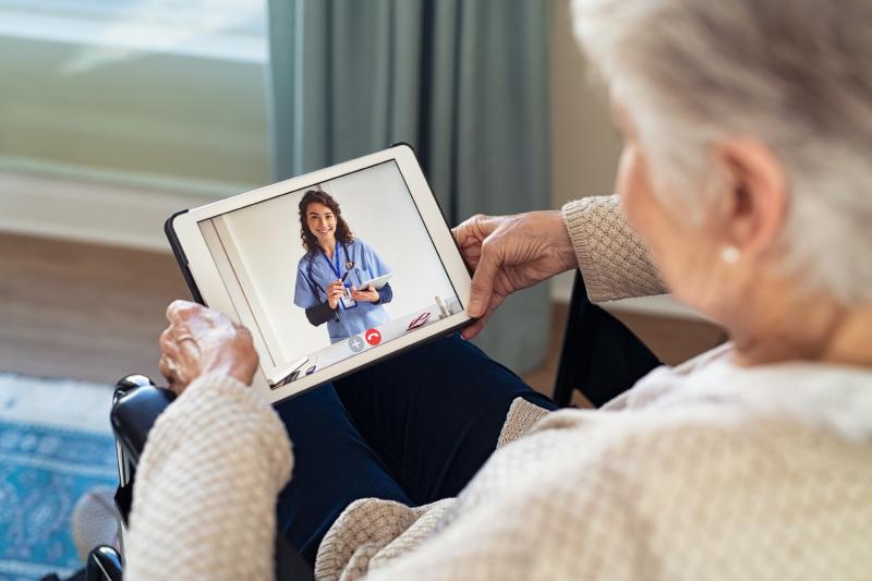 An old lady talking to a heath profession on her ipad