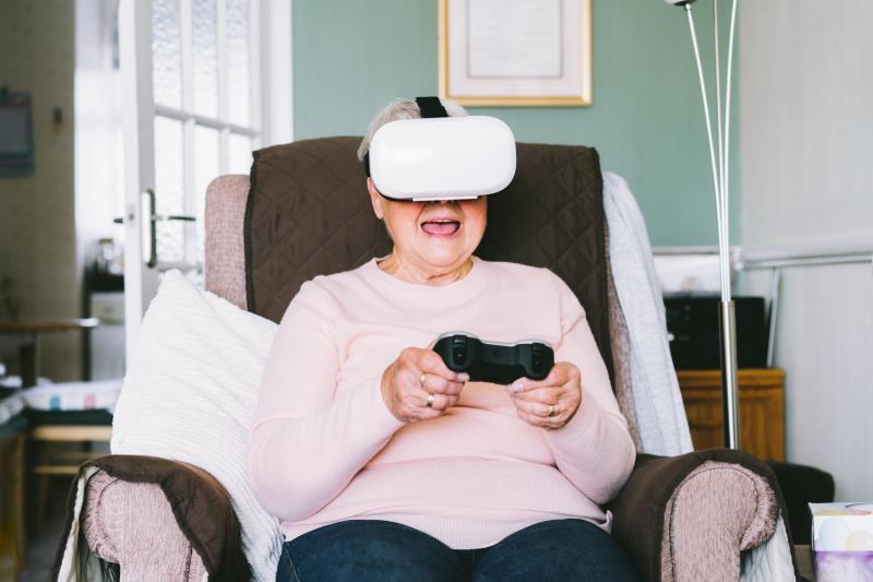 An old lady playing games using VR